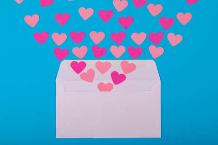 Directly above view of pink hearts coming out from white envelope blue background, copy space. valentine's day and love concept.の写真素材