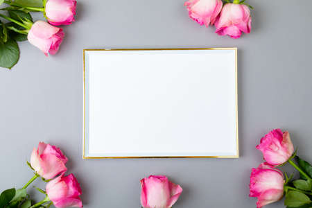 Overhead view of fresh pink roses and blank frame isolated on gray background, copy space. valentine's day, flower and love concept.の写真素材