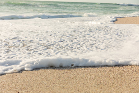 White sea foam with wave splashing on shore at beach on sunny day. natural beauty.の写真素材