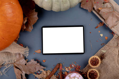 Composition of halloween decoration with pumpkin and tablet with copy space on grey background. halloween tradition and celebration concept digitally generated image.の写真素材
