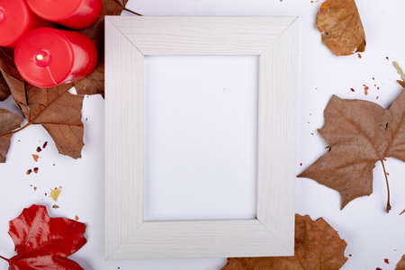 Composition of halloween decoration with leaves and frame with copy space on white background. halloween tradition and celebration concept digitally generated image.の写真素材