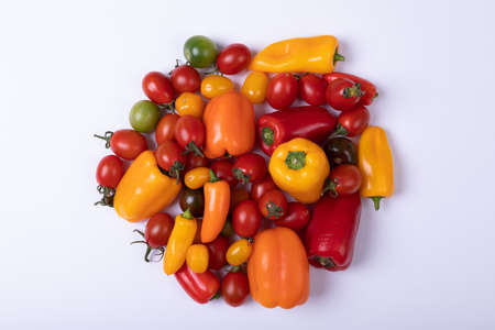 Overhead view of fresh tomatoes with bell peppers on white background, copy space. unaltered, food,...