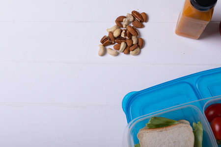 Overhead view of healthy food and tiffin box by juice bottle over white background, copy space. unaltered, food and healthy eating concept.の写真素材