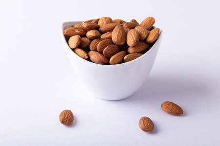 Bowl full of nutritious almonds against white background. unaltered, healthy food, snack, organic, nut and dried food.の写真素材