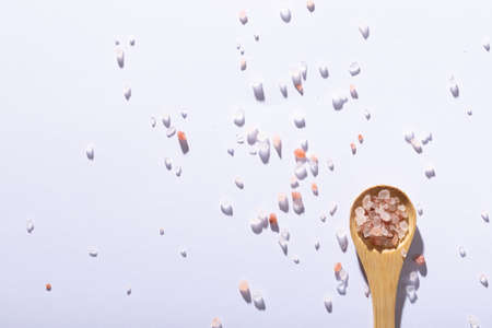 Overhead view of pink himalayan rock salt on wooden spoon on white background. unaltered, ingredient, food, rock salt and seasoning.の写真素材