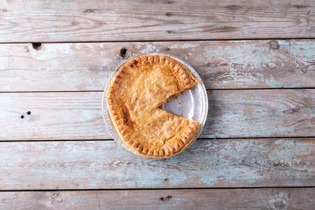 Directly above shot of baked stuffed pie sliced in plate on wooden table. unaltered, copy space,...