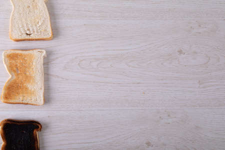 Directly above shot of toasted and burnt bread slices in a row on table with copy space. unaltered,...