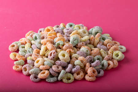 Close-up of ring shape breakfast cereal over pink background. unaltered, breakfast, snack and food...