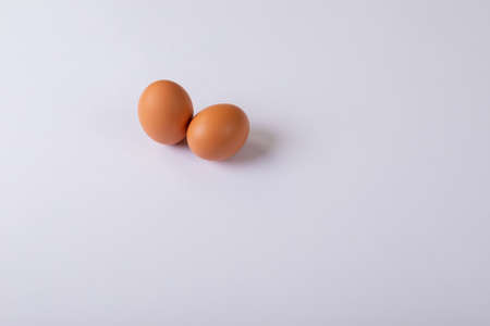 High angle view of two brown eggs on table with blank space. unaltered, copy space, healthy food, raw food, organic, protein, fresh and still life.の写真素材