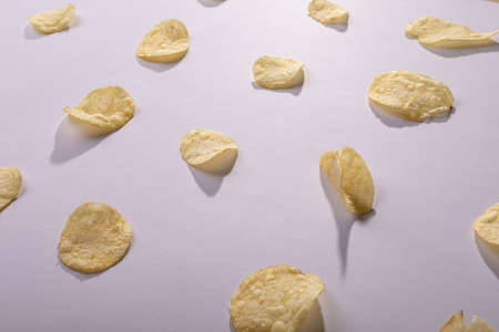 High angle view of potato chips arranged side by side on gray background. unaltered, unhealthy food, snack, arrangement and salty snack.の写真素材