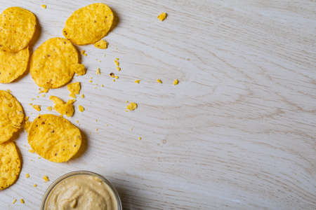 Overhead view of crunchy chips with dip in bowl on table with empty space. unaltered, copy space, unhealthy food, snack, dipping sauce, crunchy and savory food.の写真素材