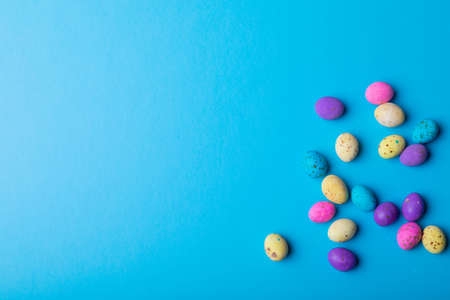 Overhead view colorful eater candies on blue background with copy space. unaltered, cultures,...