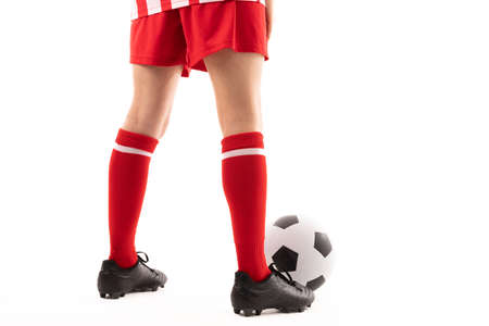 Low section of caucasian young female player standing by soccer ball against white background. unaltered, sport, soccer shoe, sock, copy space, athlete and women&#39;s soccer.の写真素材