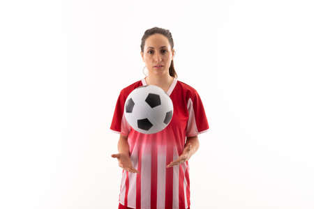 Portrait of caucasian young female player with soccer ball standing against white background....
