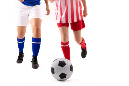 Low section of caucasian and biracial young female soccer players playing soccer. white background, unaltered, sport, sports uniform, competition, rivalry, athlete and women's soccer.の写真素材