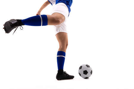 Low section of biracial female soccer player kicking soccer ball against white background. unaltered, sport, copy space, sports uniform, sock, athlete and women's soccer.の写真素材