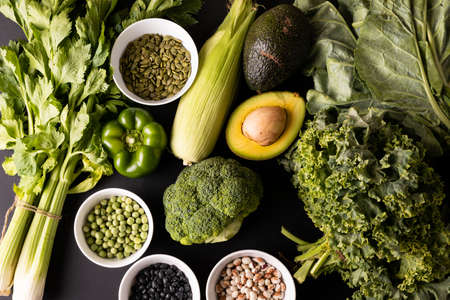 Overhead view of various green vegetables, fruit, herb with seeds and legumes on table. unaltered,...