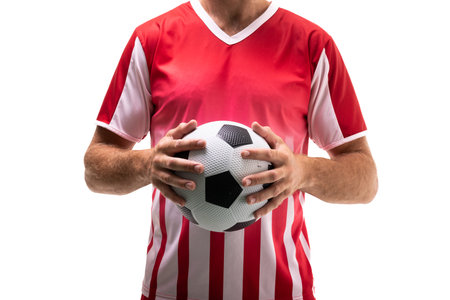 Midsection of young male caucasian player holding soccer ball standing against white background. unaltered, sport, competition and match concept.の写真素材