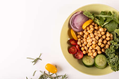 Overhead view of fresh healthy food in bowl by herb on white background, copy space. unaltered,...