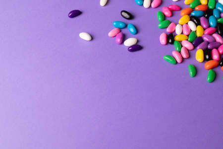High angle view of copy space by multi colored candies on purple background. unaltered, sweet food and unhealthy eating concept.の写真素材