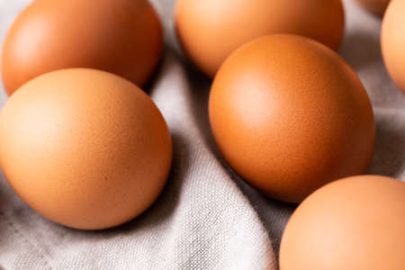 High angle close-up of fresh brown eggs on gray napkin. unaltered, food, healthy eating concept.