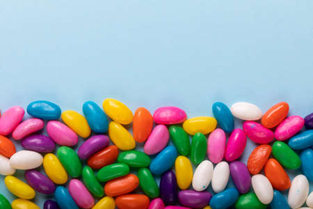 Overhead view of copy space and multi colored candies over blue background. unaltered, sweet food...