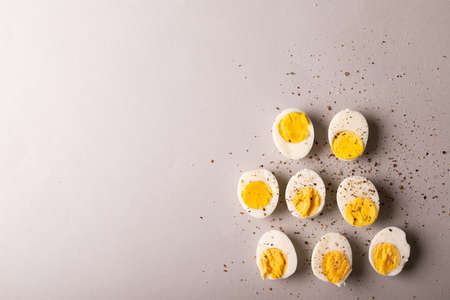 Overhead view of peppercorn seasoning on boiled white eggs by copy space on gray background. unaltered, food, healthy eating and organic concept.の写真素材