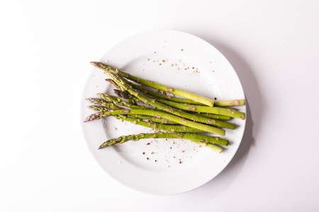 Overhead view of asparagus with seasoning in plate on white background. unaltered, food, healthy...