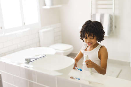Smiling cute hispanic boy brushing in bathroom at home. unaltered, childhood, hygiene and routine...