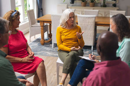 Caucasian senior woman talking with multiracial people at group therapy session. unaltered, support,...