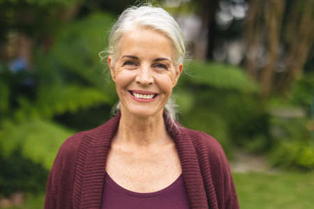 Portrait of cheerful caucasian senior woman with white hair in backyard. unaltered, lifestyle,...