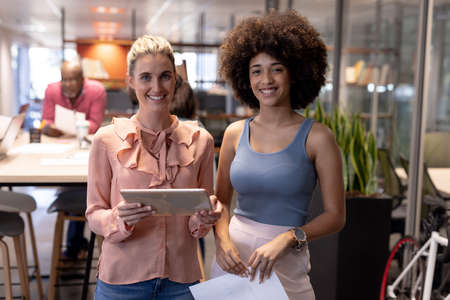 Portrait of smiling multiracial businesswomen working together at modern workplace. unaltered,...