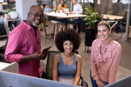 Portrait of happy multiracial businessman and businesswomen working together at modern workplace....