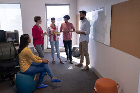 Multiracial male and female advisors discussing strategy in boardroom during meeting at workplace....