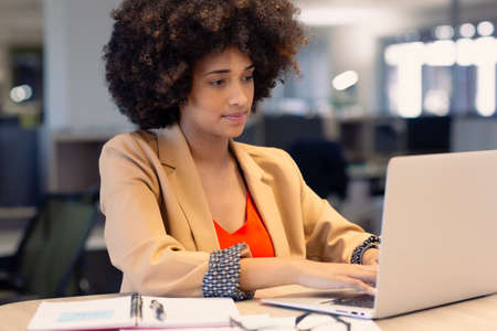 Confident afro female african american advisor using laptop while working at modern office....