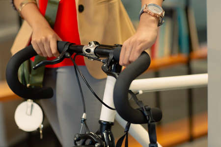 Midsection of african american businesswoman holding bicycle at workplace. unaltered,...