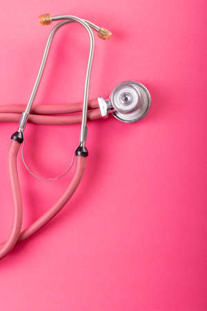 Close-up of pink stethoscope isolated against pink background, copy space. medical, equipment, heart, cardiology and healthcare concept.の写真素材