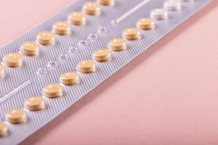 High angle close-up of blister pack of medicines isolated against pink background, copy space. pill,...