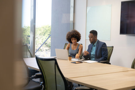 Multiracial young colleagues planning strategy in boardroom during meeting at modern workplace. unaltered, business, teamwork and modern office concept.の写真素材