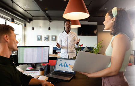 Multiracial young colleagues discussing during meeting in creative office. Unaltered, creative business, workplace, planning, teamwork, strategy, diversity.の写真素材