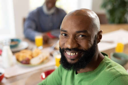Image of happy african american man smiling at camera. Lifestyle, baking and spending time at home...