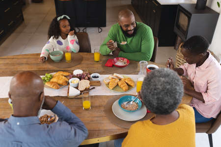 Image of happy multi generation african american family eating breakfast. Family and spending...