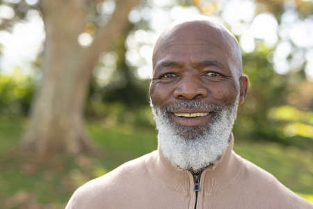 Image of happy african american man smiling at camera in garden. Lifestyle and spending time at home...