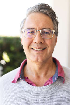 Vertical image of happy senior caucasian man smiling at camera. Lifestyle and spending time at home...
