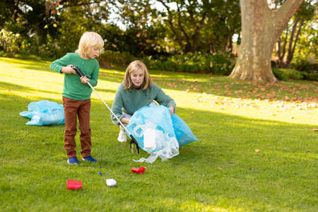 Image of happy caucasian grandmother and grandson with rubbish bags in garden. Family, recycling and eco awareness concept.の写真素材