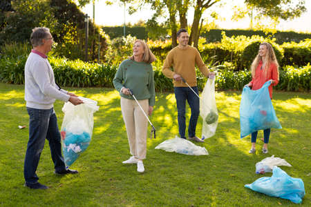 Image of happy multi generation caucasian family collecting waste in garden. Family and spending...