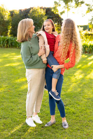 Vertical image of happy three generation caucasian women in garden. Family and spending quality time...