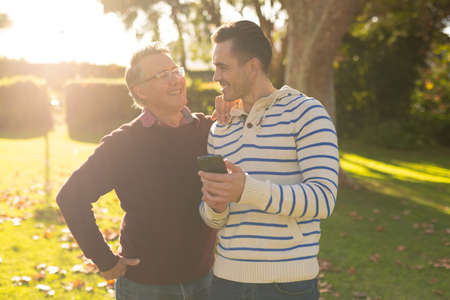 Image of happy caucasian father and adult son taking selfie in garden. Family and spending quality time together concept.の写真素材