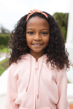 Vertical image of happy african american girl posing at camera. Lifestyle and spending time at home...