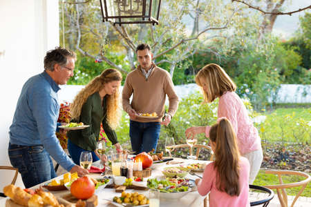 Image of multi generation caucasian family preparing outdoor dinner. Family and spending quality...